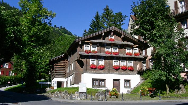 Altes Schweizerhaus mit roten Geranien